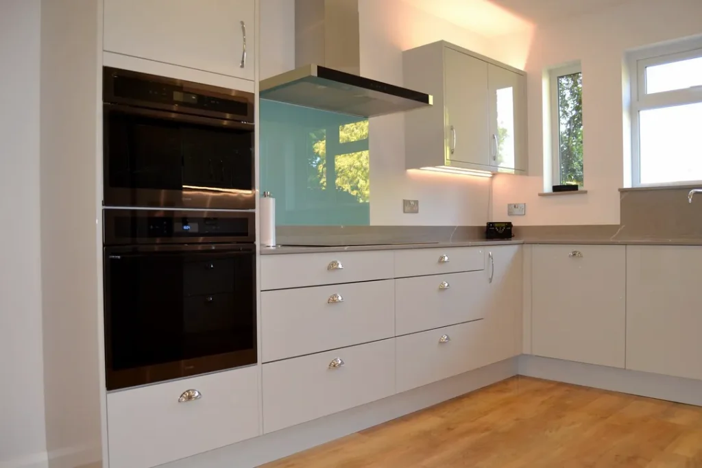 Modern kitchen with built-in cooker, white glossy kitchen units and hob.