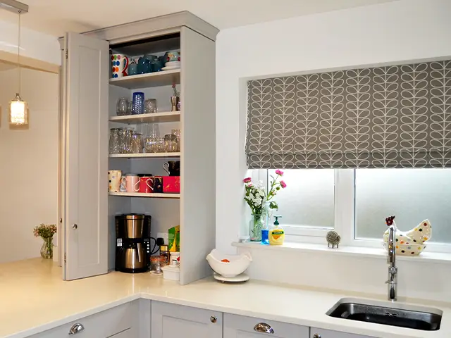 A kitchen counter top cabinet designed to house a coffee machine, mugs and glasses.
