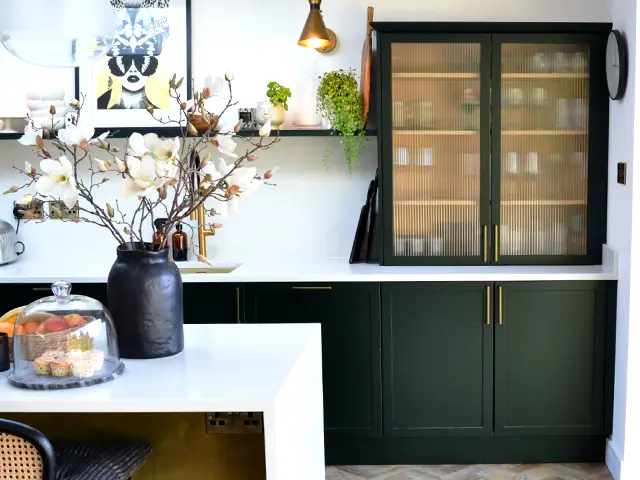 A counter top drinks cabinet in a modern green and white coloured shaker style kitchen.