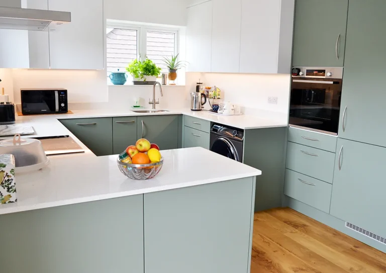 A newly fitted kitchen with Reed Green and White Porcelain coloured doors and a White Nova Quartz worktop.