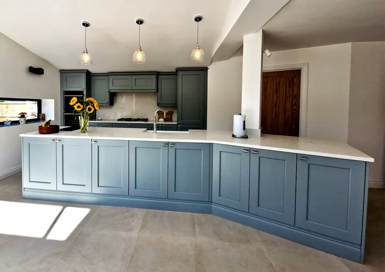 Blue painted timber shaker style kitchen, with Neff combination oven and pendant lights over the island.