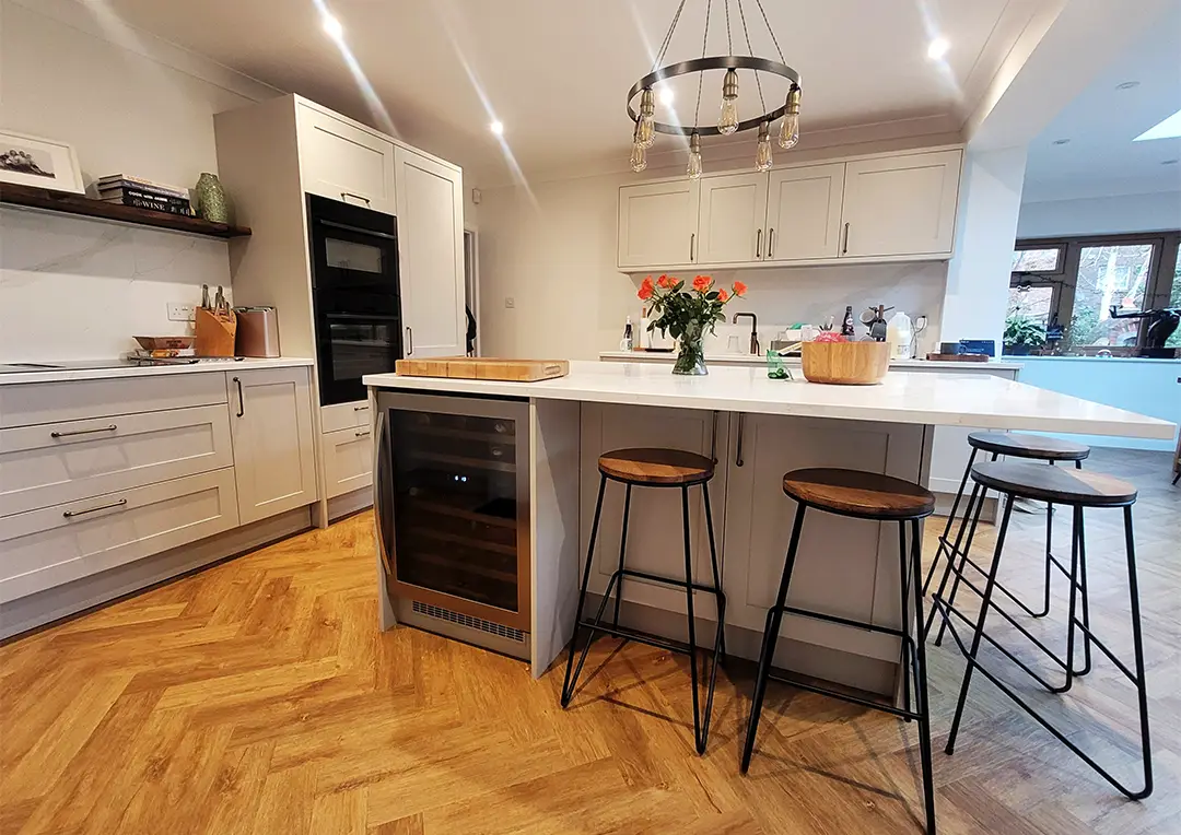 Kitchen with timber doors in painted taupe, kitchen island, wine cooler, stools and built in oven.