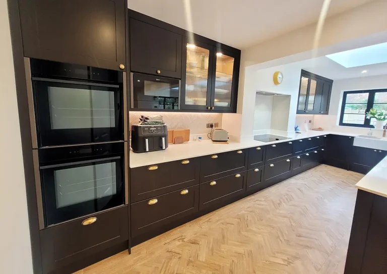 Traditional shaker style doors in matt black with antique brass cups and knobs, quart worktop and induction hoband oven.