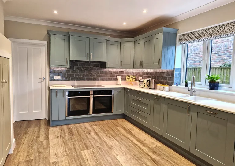 Fjord painted timber shaker style kitchen with brushed steel handles, Quartz worktops and built in induction hob.